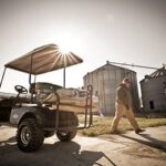 Man walking away from golf cart.