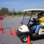 Golf cart parked outside of traffic cones.