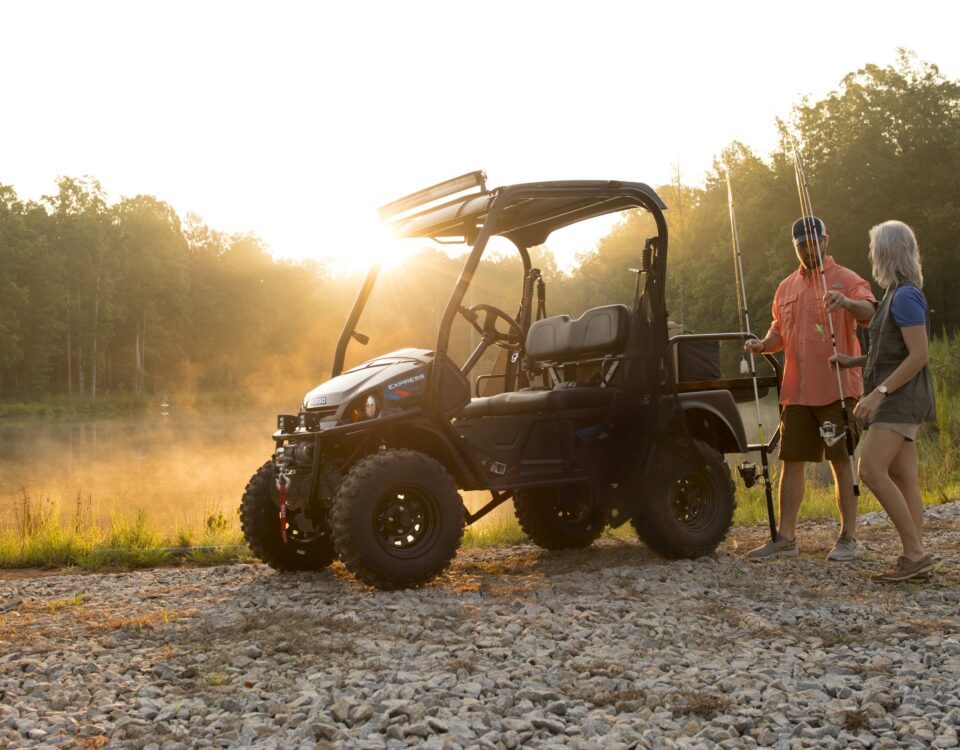 a couple loads fishing poles onto their off road cart