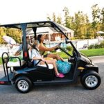 Mom and kids riding golf cart in neighborhood.