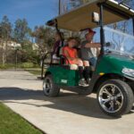 Family riding golf cart in neighborhood.