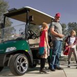 Father and kids leaving golf cart to play sports.