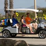 Family riding golf cart to the beach.