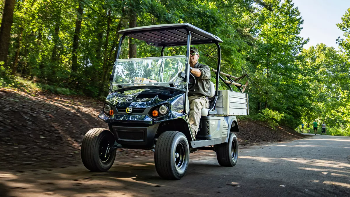 Worker driving black Cushman PRO-X.