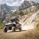 People riding ATV in mountains.