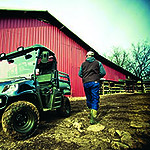 Cushman cart parked outside a barn and man walking away.