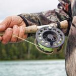 Fisherman holding fishing rod.