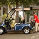 Woman lifting something in the back of her golf cart.