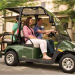 Family riding golf cart in neighborhood.