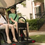 Family riding cart in neighborhood.