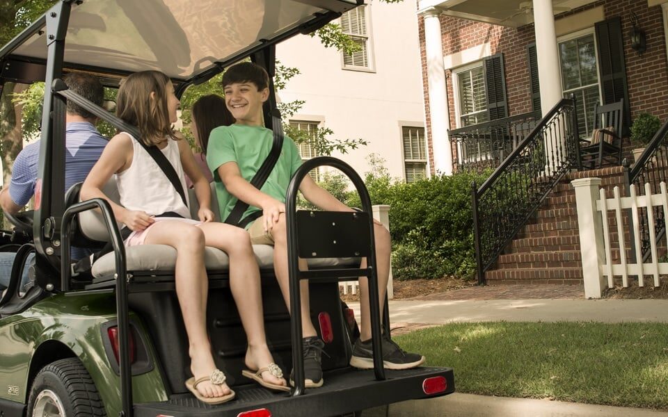 Family riding cart in neighborhood.