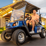 Two men riding golf cart in neighborhood.