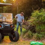 Man doing yard work with cart.