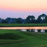 Sunset of golf course with pond.