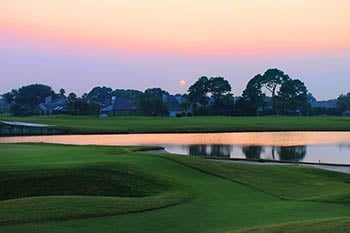 Sunset of golf course with pond.