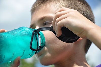 Boy drinking water from water bottle.