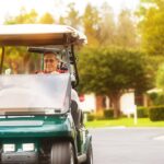 A retired man driving a golf cart in his neighborhood