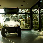 A woman looking out of a window considering whether to buy the exhibited golf cart