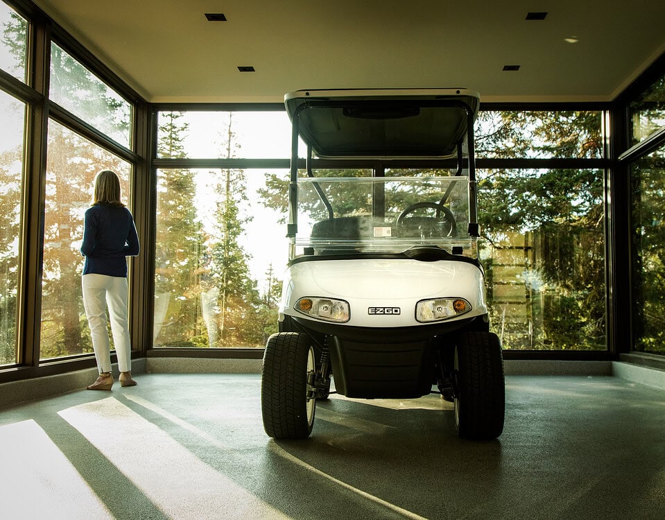 A woman looking out of a window considering whether to buy the exhibited golf cart
